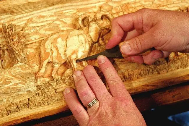 Hands working on an elephant carving