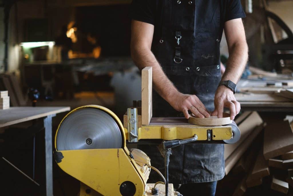 Man using a palm sander in a workshop