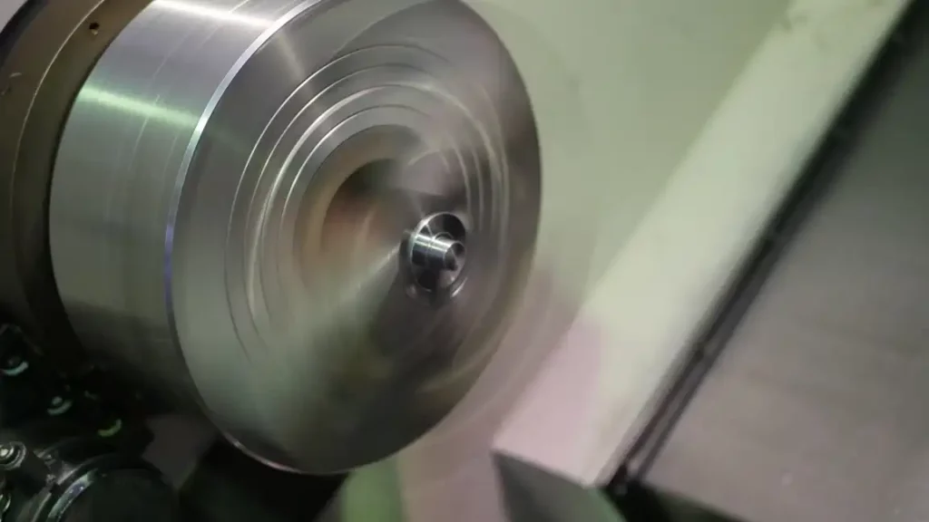 The lathe chuck rotates at high speed with the metal workpiece clamped