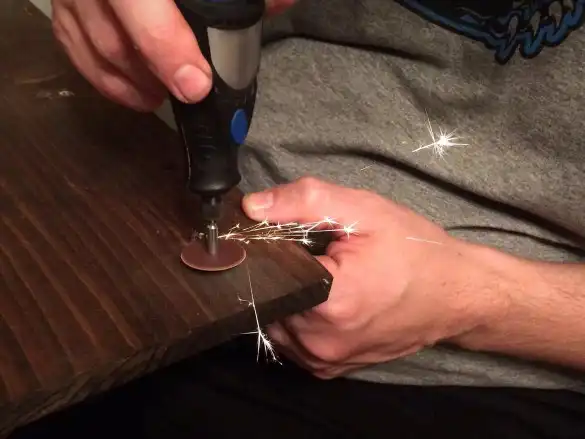 filing the back of a wooden project with a dremel