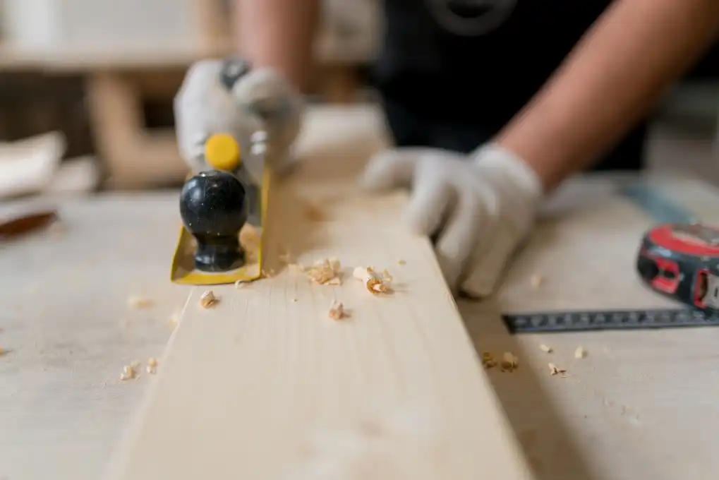 man planning and shaving wood