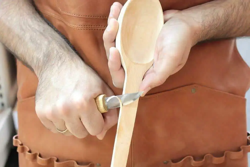 Man using a Beavercraft C1 Knife to carve a spoon