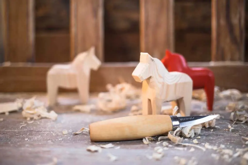 beaver craft carving knife displayed with carved wooden horses 