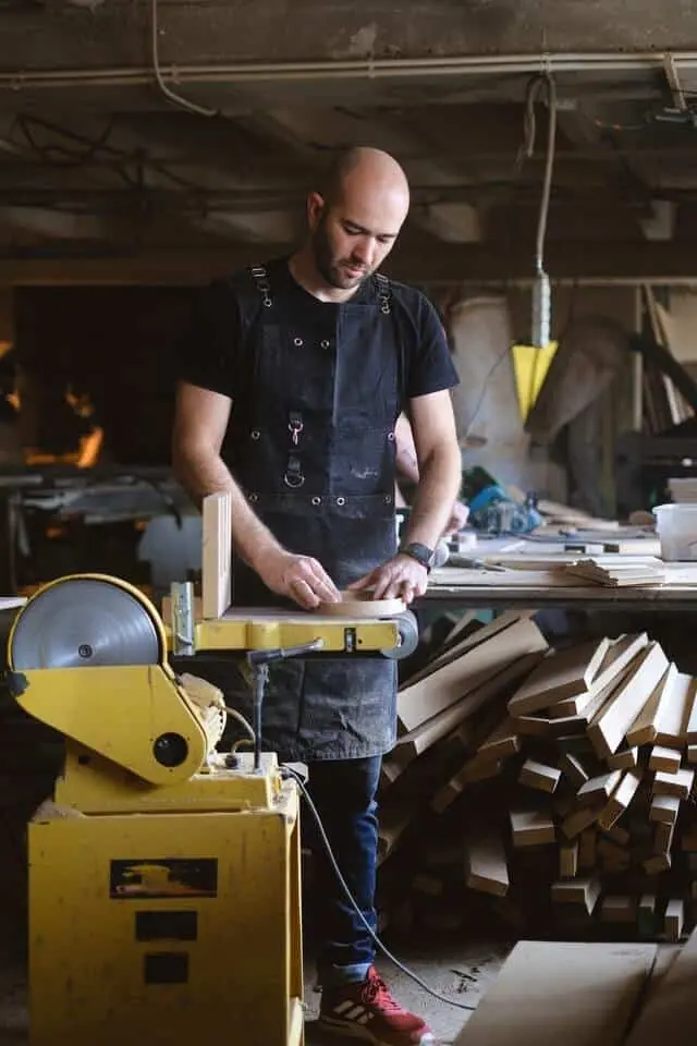 craftsman using an electric belt and disc sander